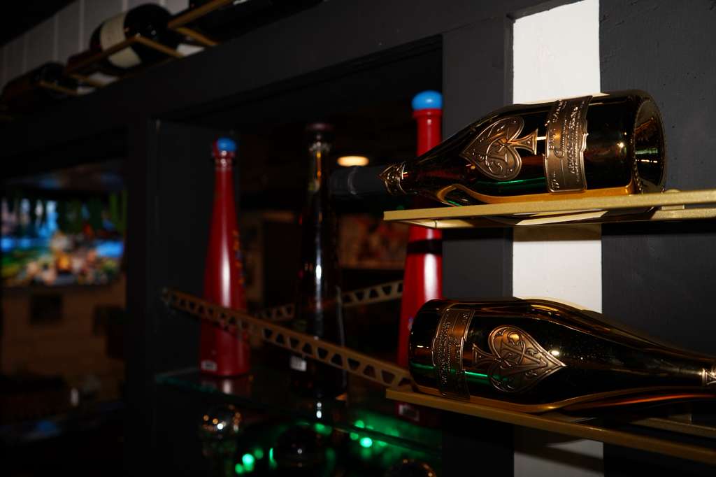 Bartender pouring a cocktail beneath the Vogue ceiling