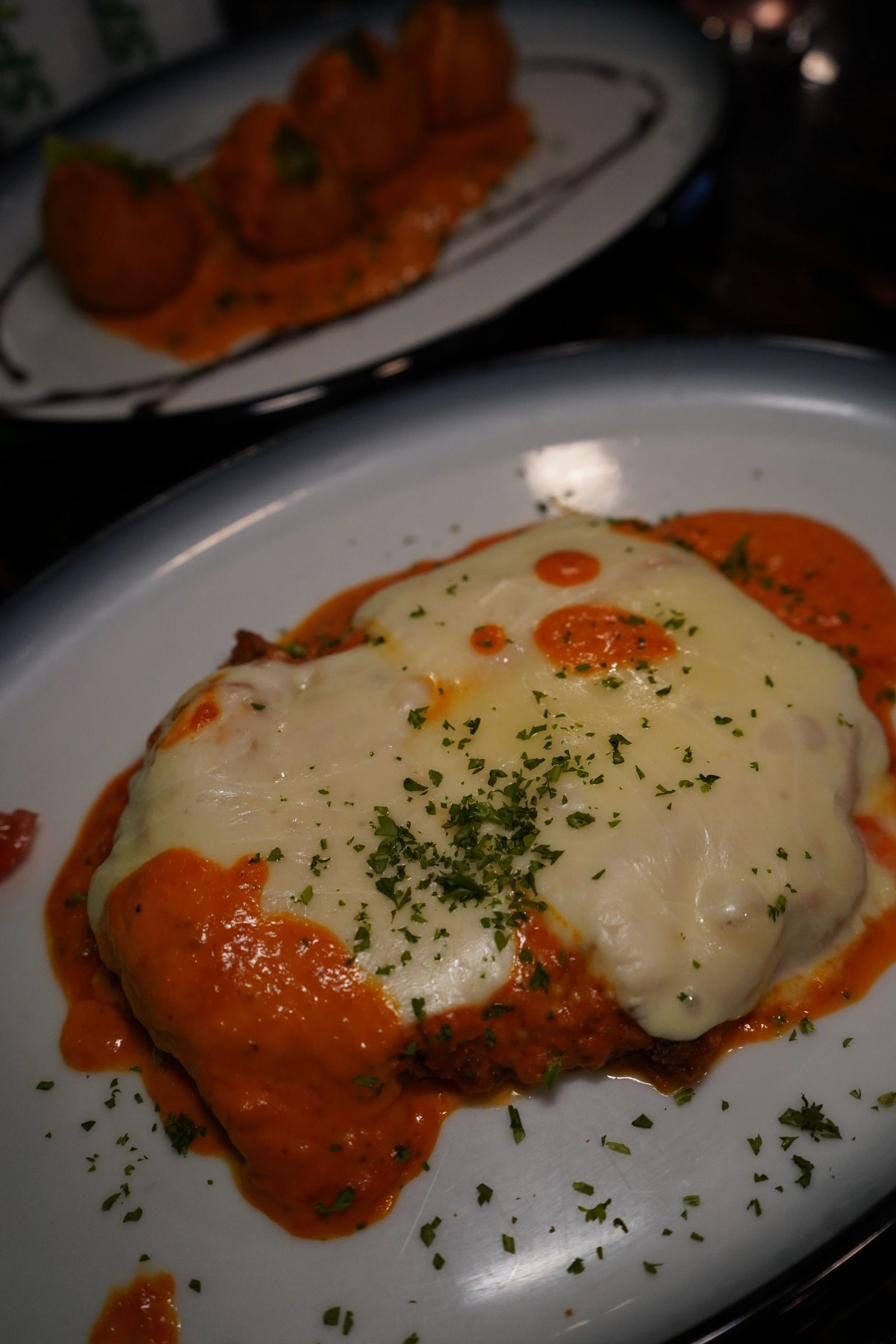 Chicken parmigiana smothered in creamy vodka sauce and melted mozzarella