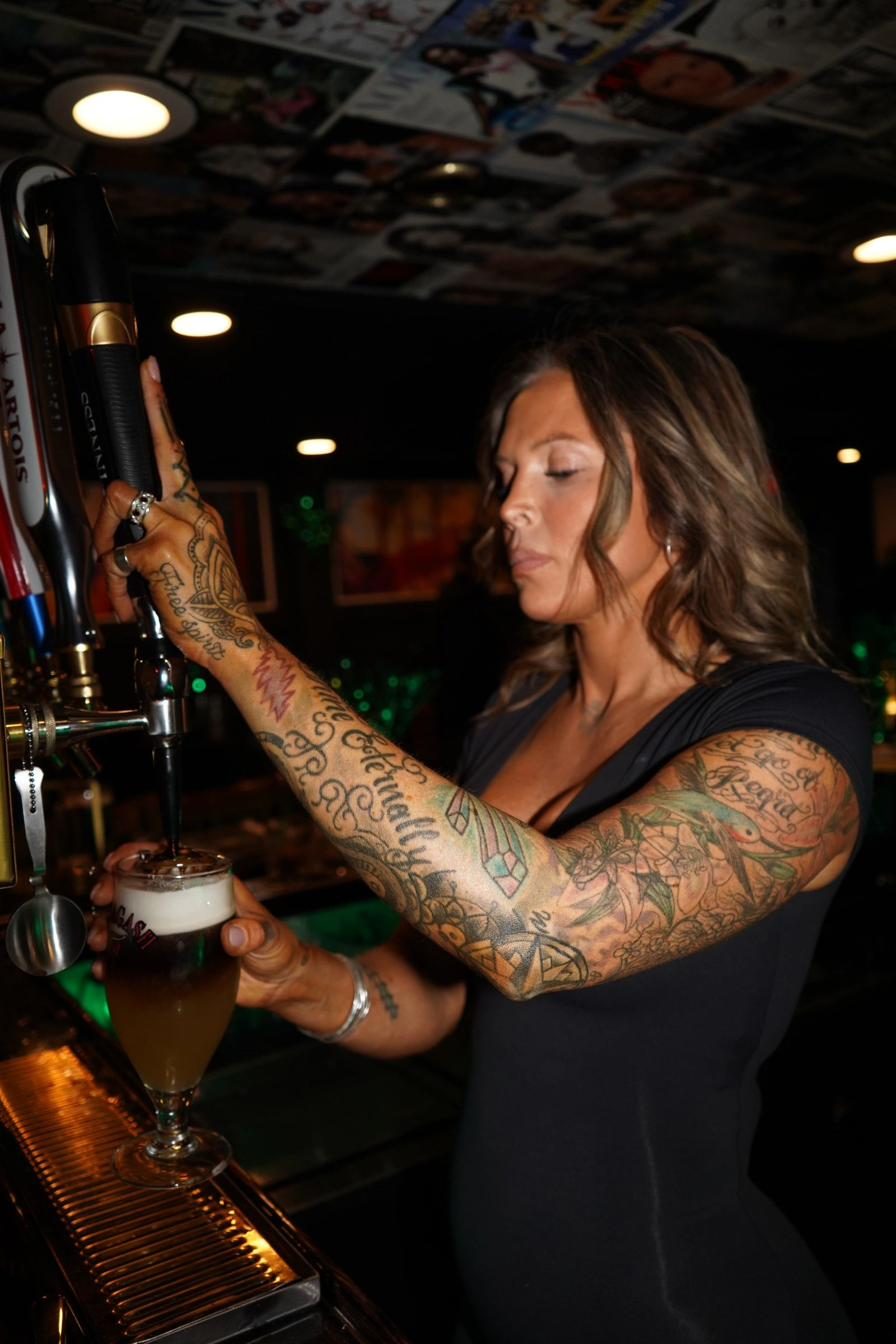 Bartender pouring a draft beer under the Vogue-covered ceiling