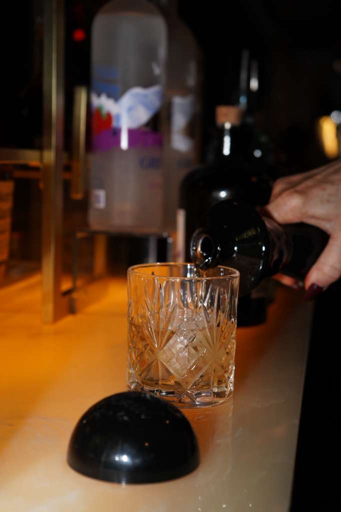 Two espresso martinis beside a holographic Chanel bag